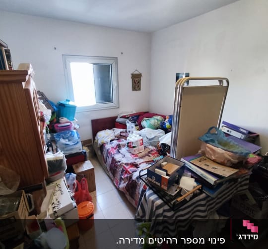 חדר עמוס בחפצים, קופסאות וארגזים על המיטה והשולחן
